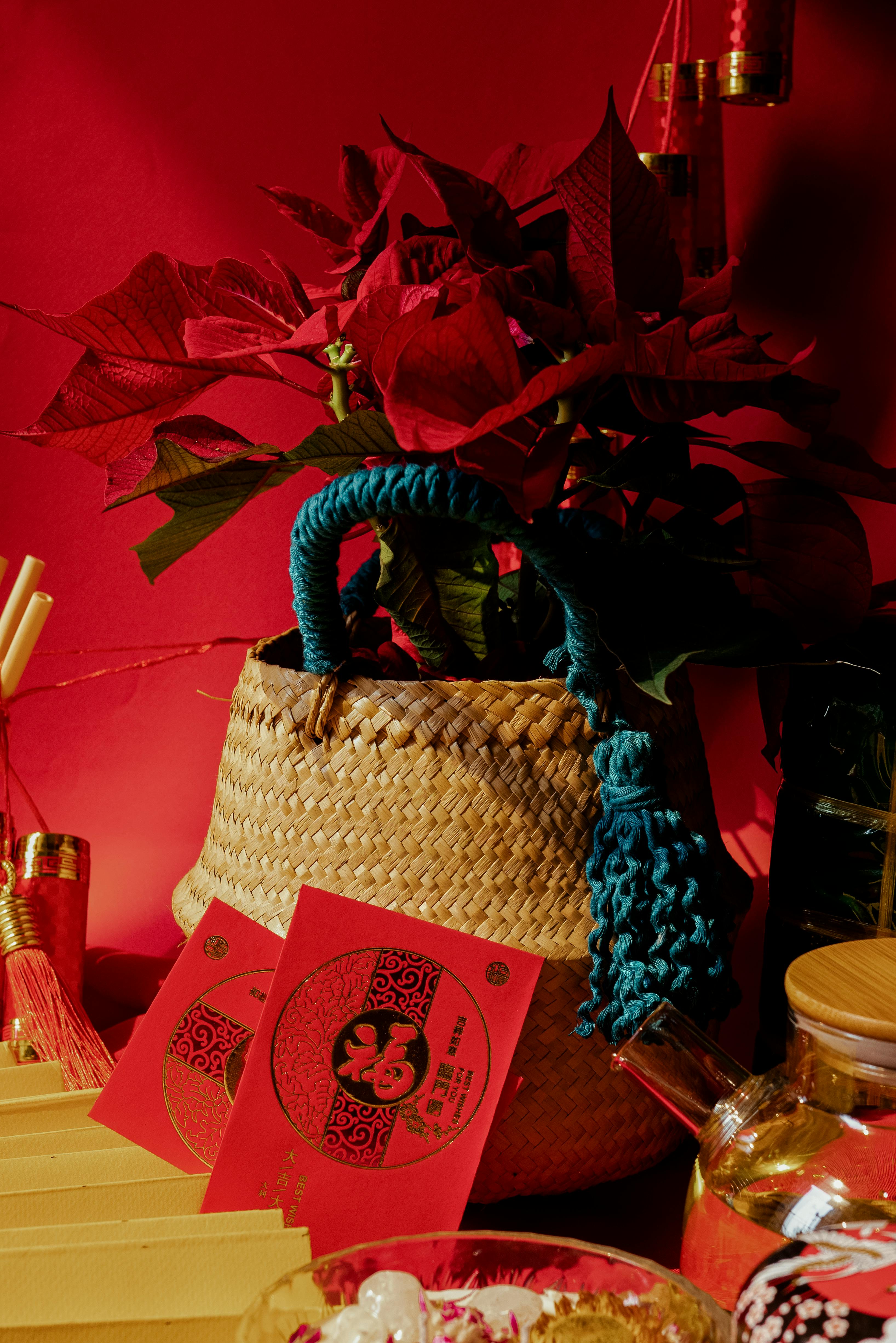 Woven basket with red envelopes and flowers for Vietnamese New Year celebration.