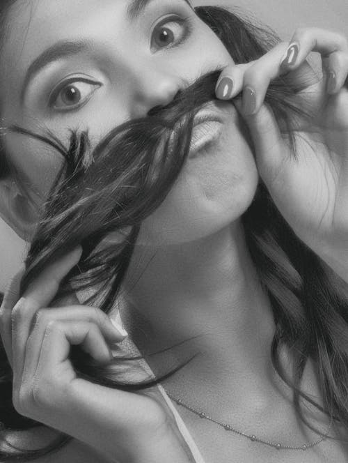 A Woman Making a Hair Moustache