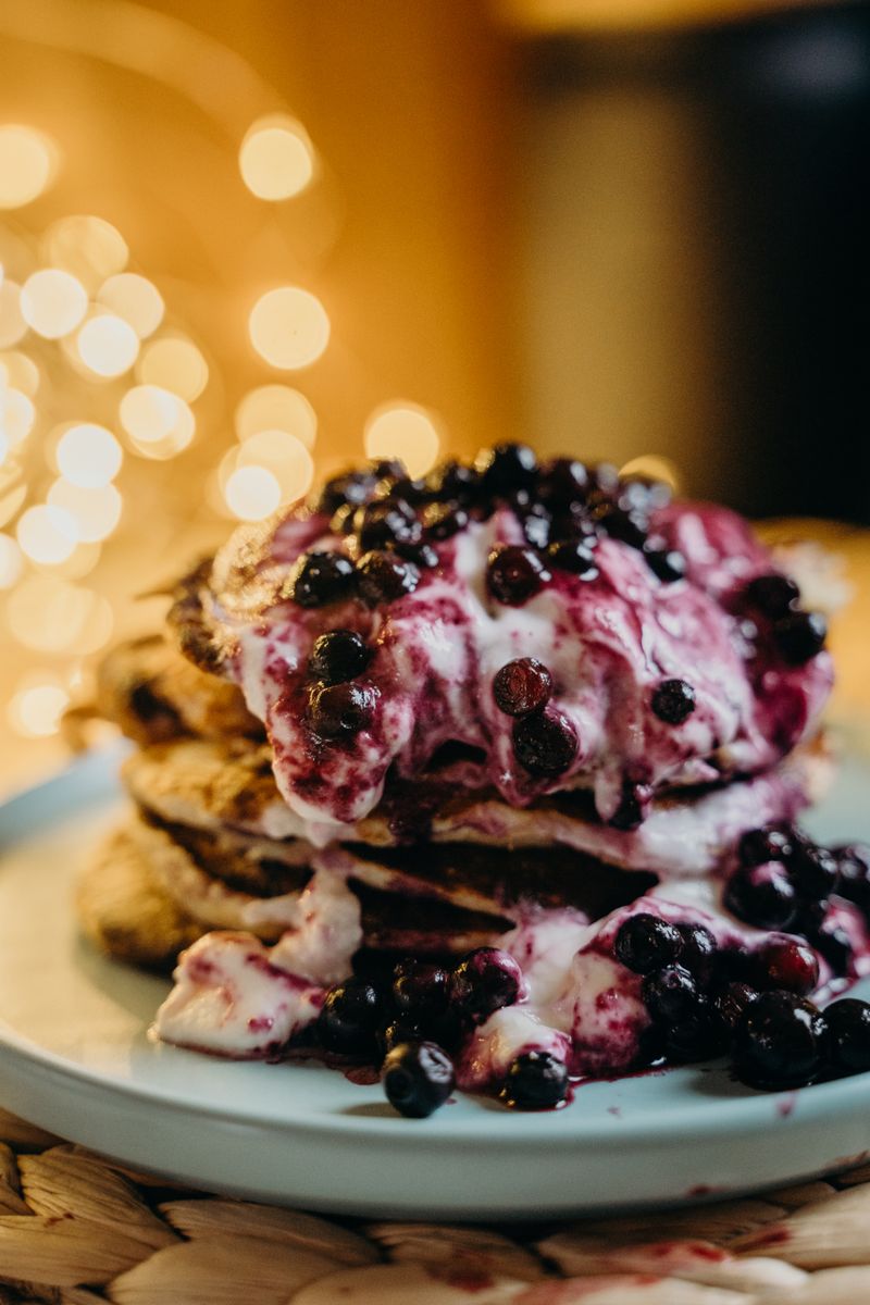 Golden-brown oat pancakes layered with yogurt and blueberries