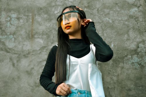 Free A Girl in Black Long Sleeves Wearing a Face Shield Stock Photo