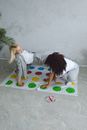 Two Women in White Shirt Playing a Game on the Floor