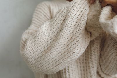 Close-up of a cream knitted sweater sleeve