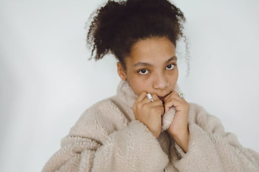 A woman in a soft fur jacket poses against a neutral background.