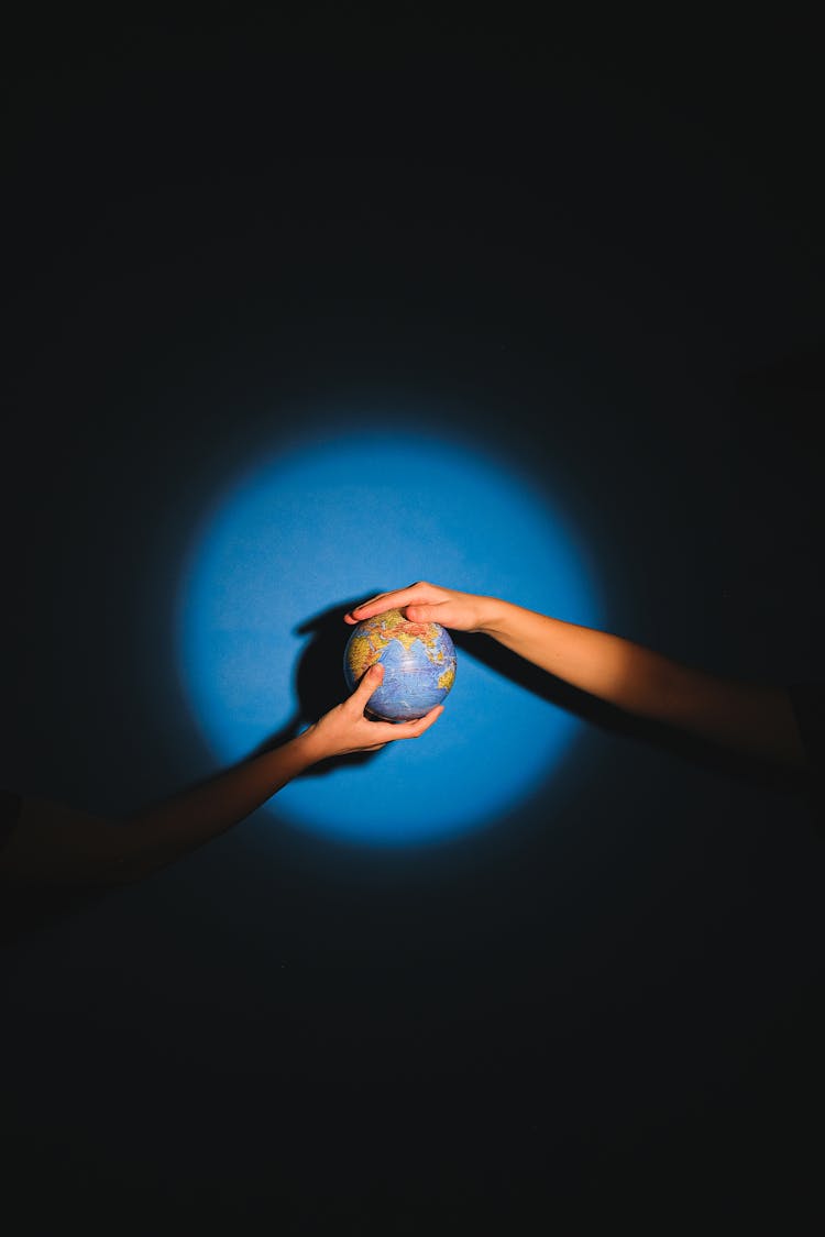 

People Holding A Globe