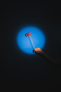 Minimalist image of a hand holding an 'OK' sign in a spotlight on a dark background.