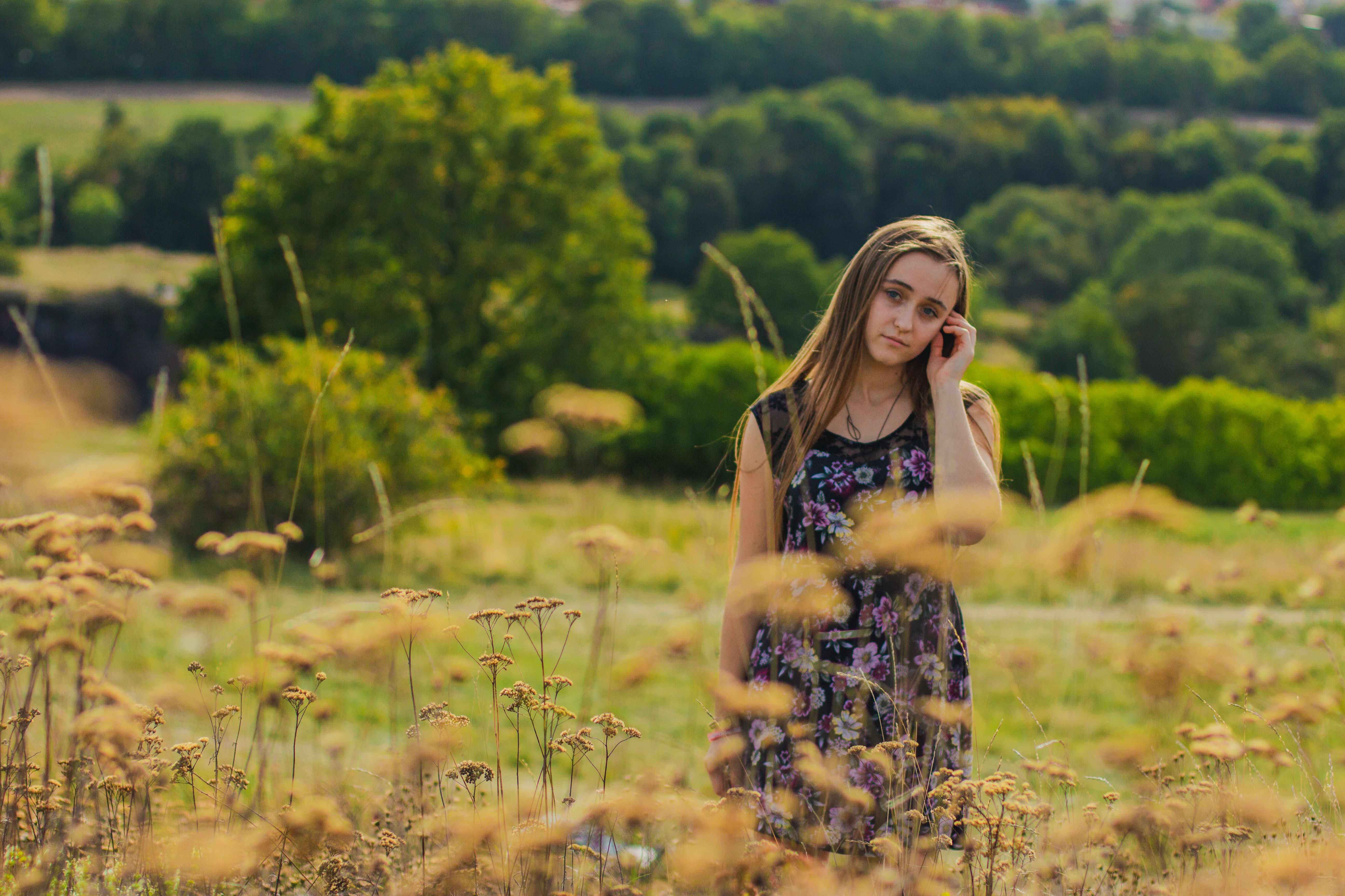 Girl in Floral Dress Standing in Grass Field · Free Stock Photo