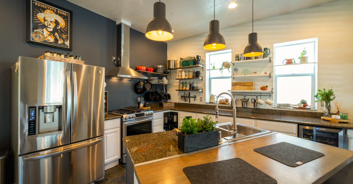 Stylish kitchen with stainless steel appliances, pendant lights, and open shelving for a contemporary look.