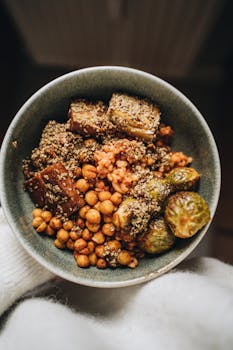 Savory vegan Buddha bowl featuring chickpeas, tofu, hemp seeds, and Brussels sprouts.