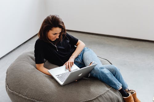 Free 
A Woman Using Her Laptop on a Bean Bag Stock Photo