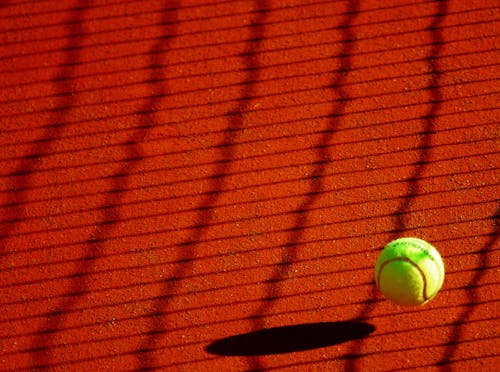 Palla Da Tennis Verde Sul Pavimento Rosso Durante La Giornata Di Sole