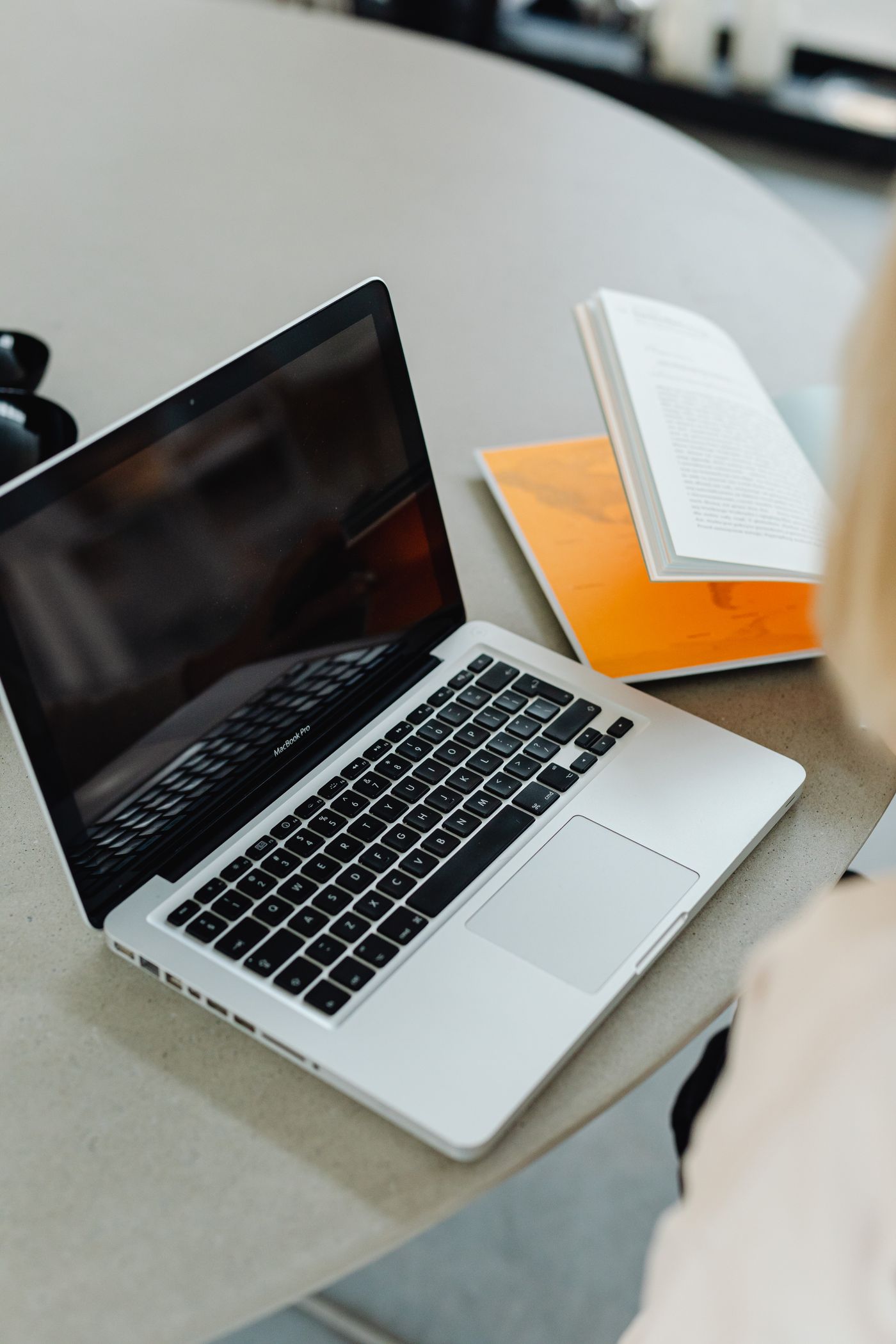 Ordinateur portable et livre ouvert posés sur un bureau