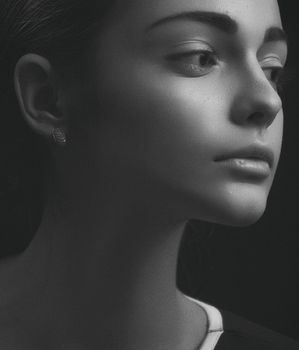 Artistic black and white portrait of a young woman, capturing emotion and elegance.