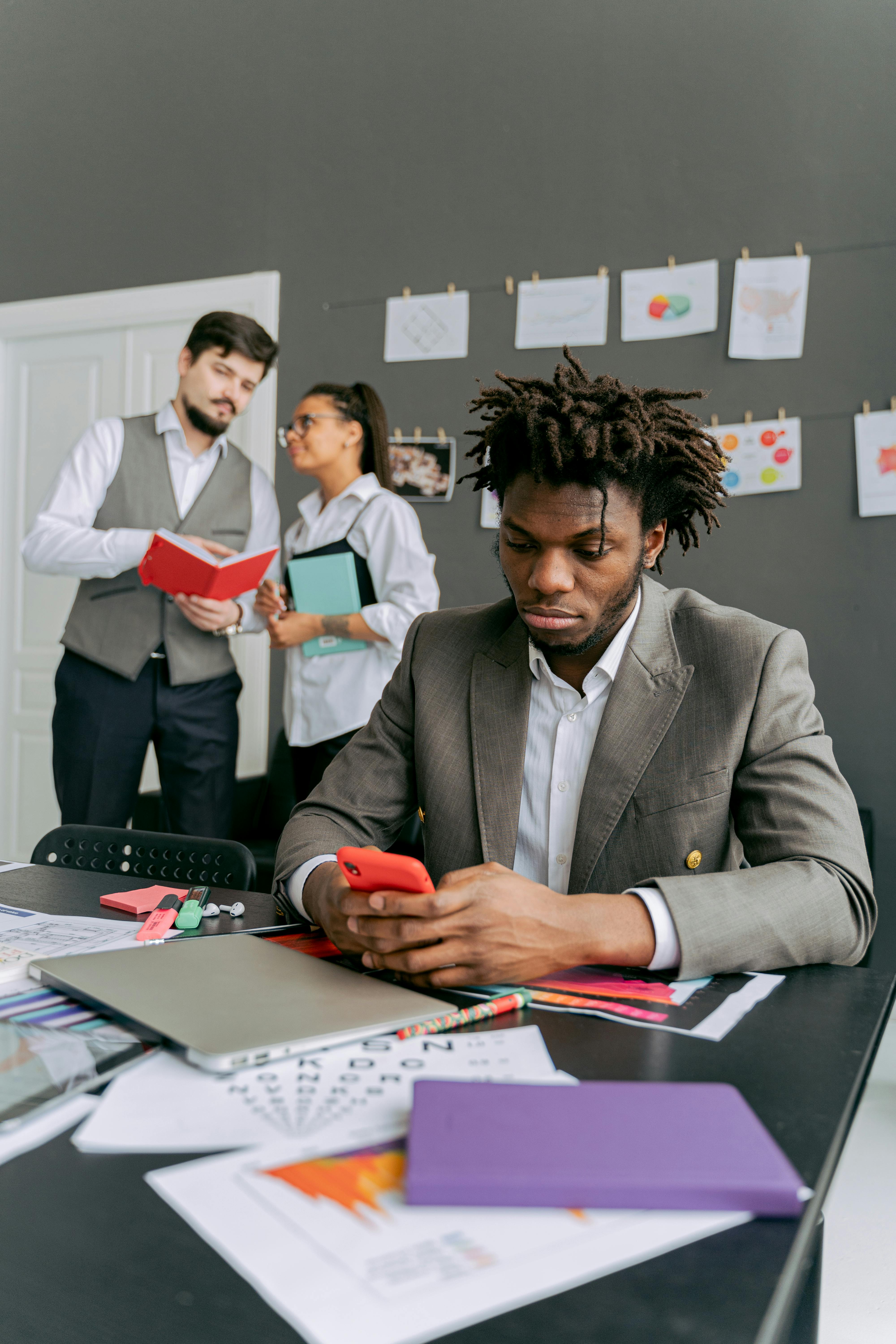 Frustrated Office Worker with his Colleague Laughing Behind his