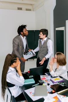 Colleagues engaged in a lively discussion around a workspace table, focusing on conflict resolution.