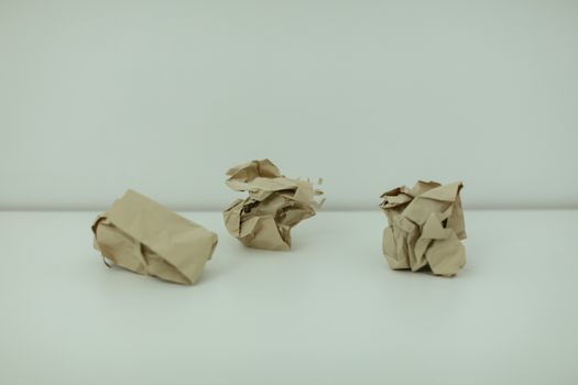 Minimalist image of three crumpled paper balls on a white surface, symbolizing burnout.
