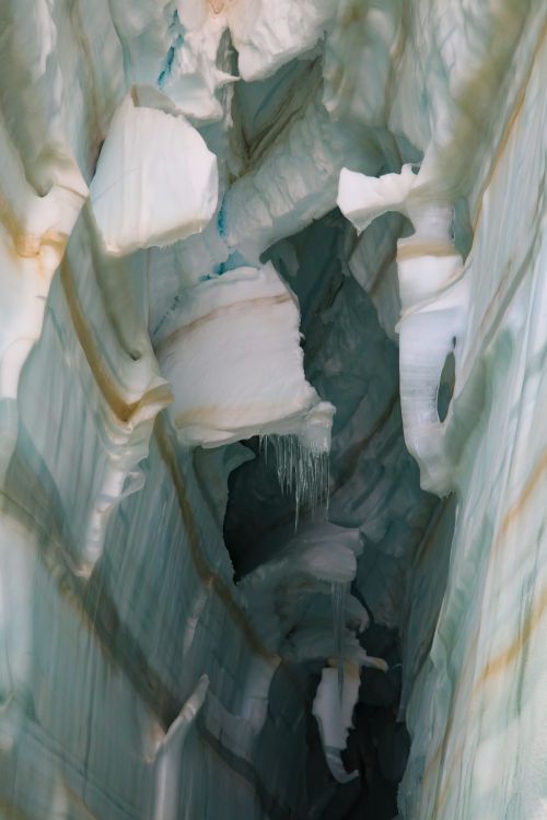 Free An intricate view of a frozen glacier ice cave with icicles and ice layers. Stock Photo