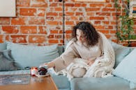 Photo of a Woman Picking Up a Mug