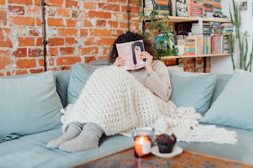 Gratis stockfoto met bedekkend gezicht, boek, chillen