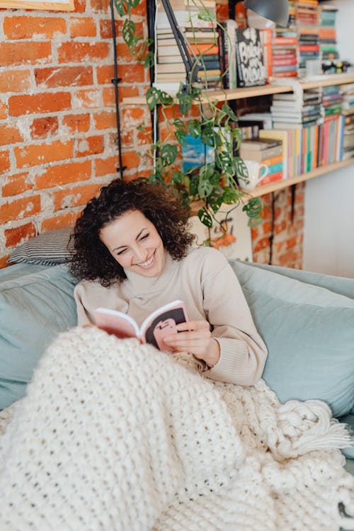 Woman Smiling while Reading a Book