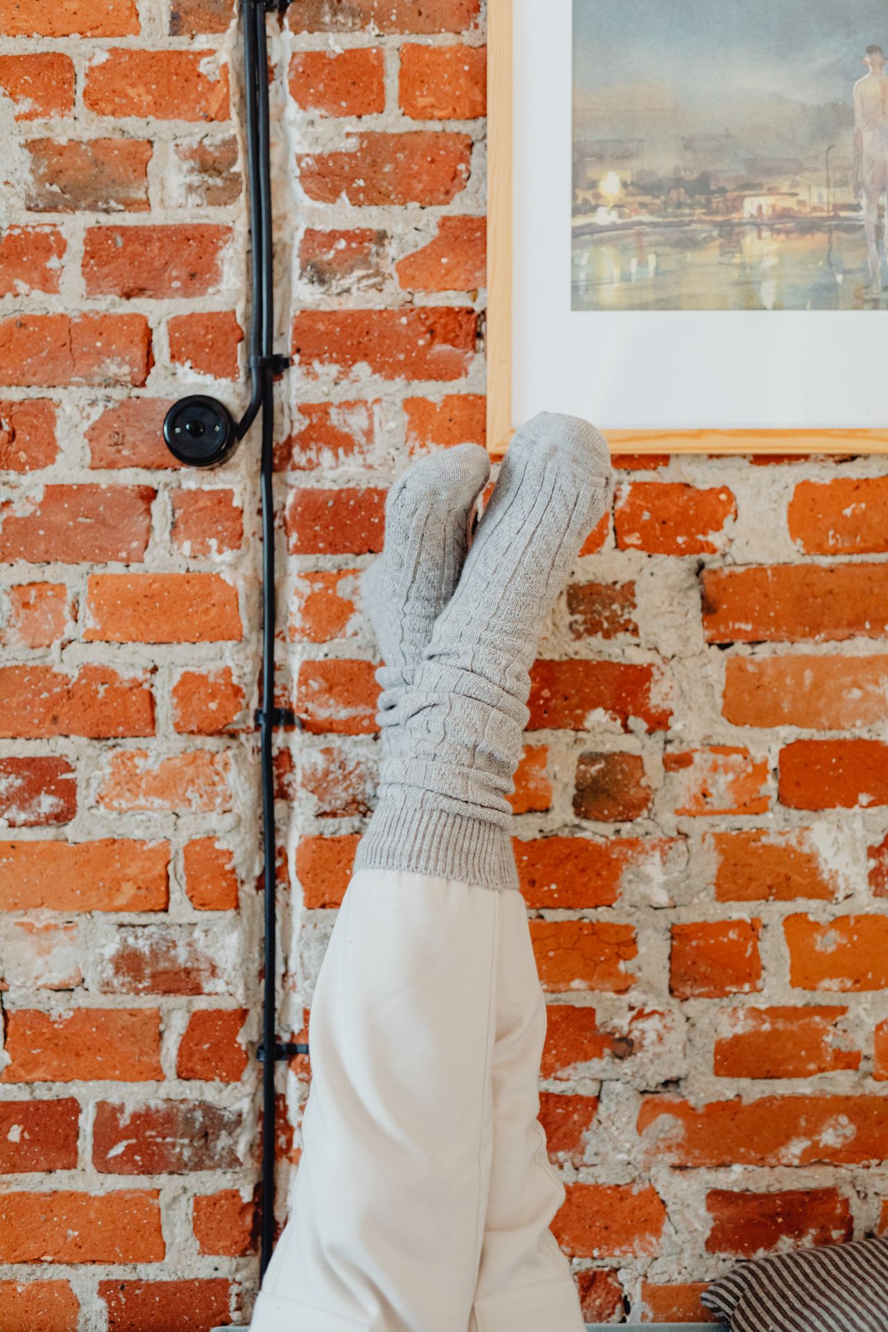gray athletic socks stretched against a brick wall