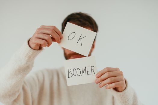 A person holding two cards with 'OK Boomer' written in bold text. — photo by Cup of  Couple