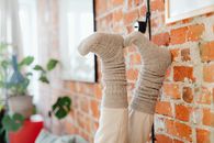 A Person Wearing Brown Socks Putting Her Legs Up on the Wall