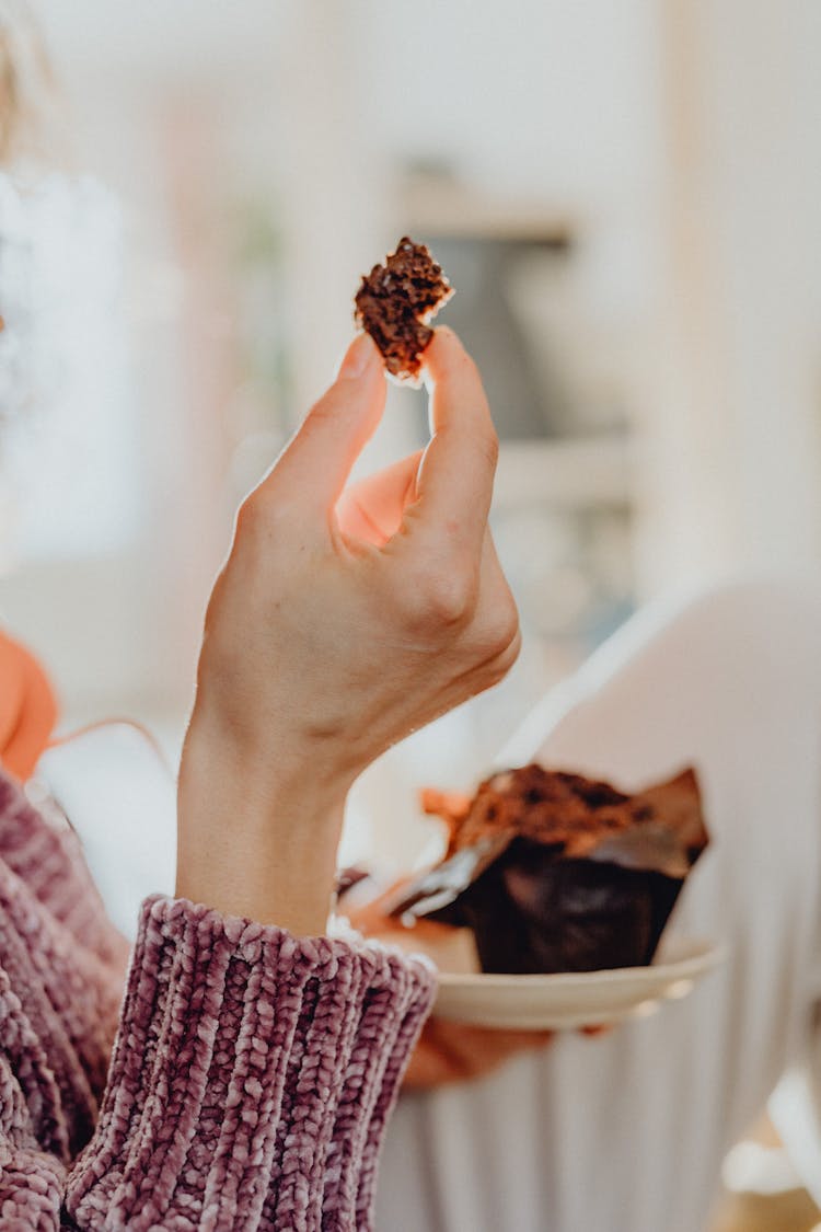 Hand Of A Young Woman Eating Chocolate Cake