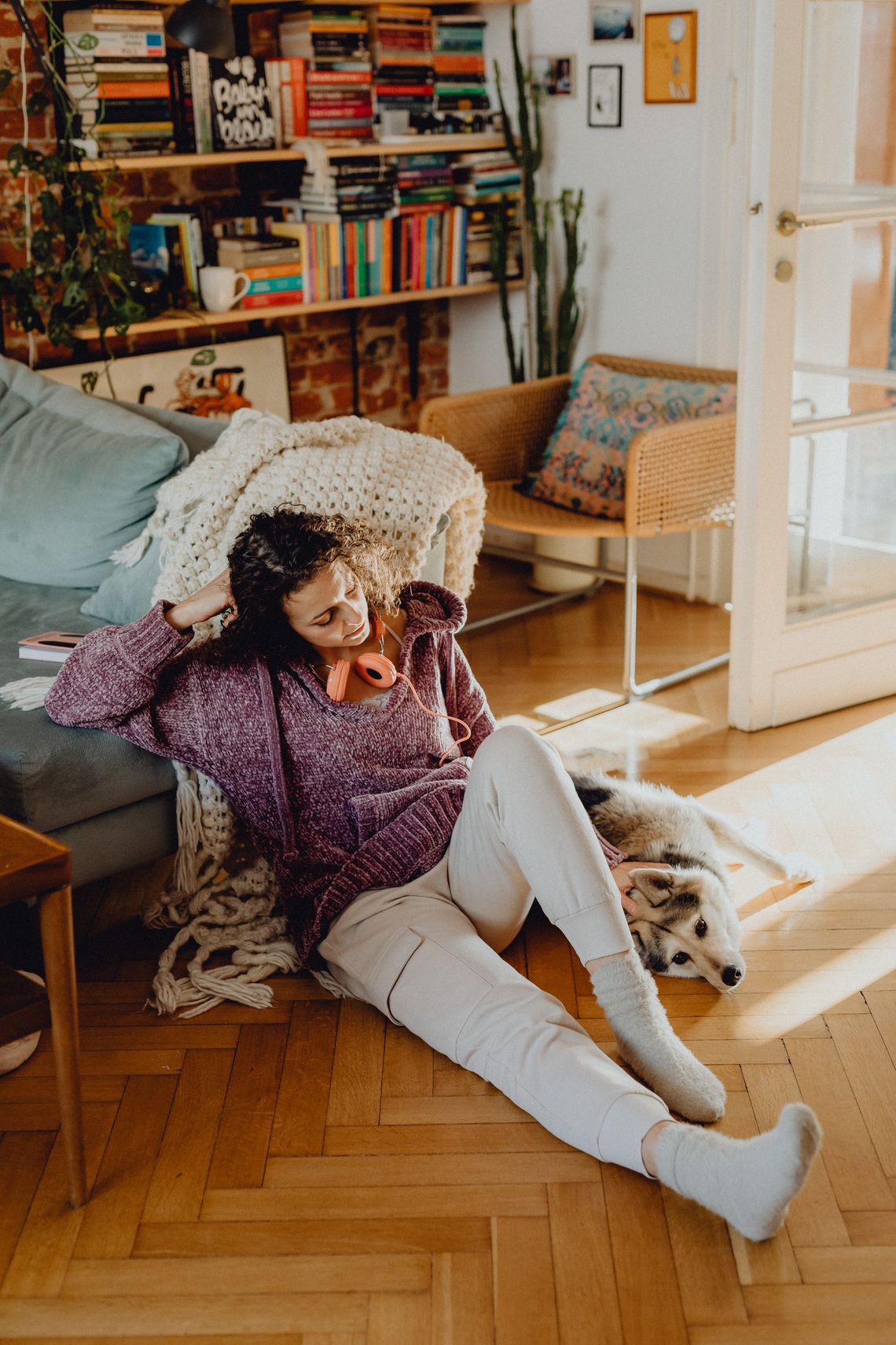 Woman sharing a peaceful moment with her dog in a sunlit, comfortable living room