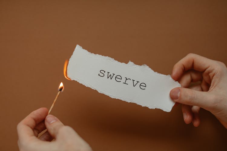 Man Burning Paper With Swerve Written On It