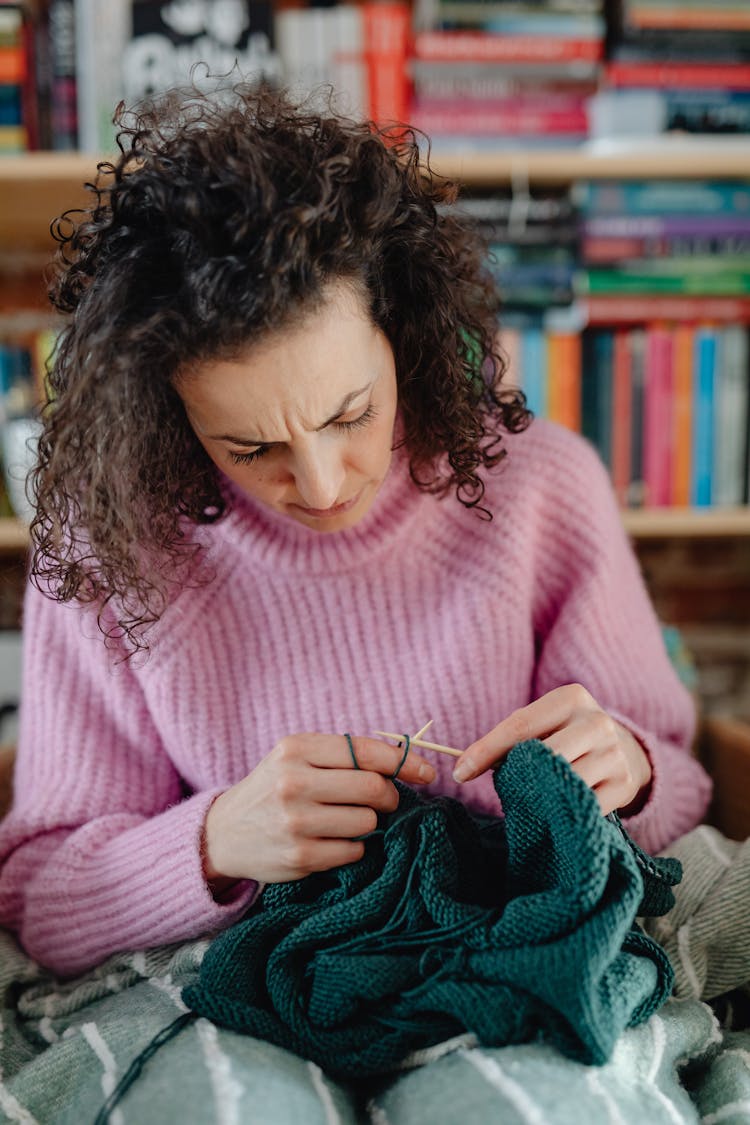 Photo Of A Woman In A Pink Sweater Knitting Dark Cyan Textile