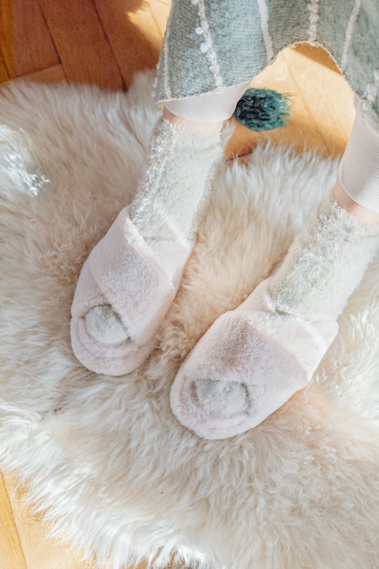 Close-up Of A Woman Wearing Fuzzy Socks And Cosy Slippers