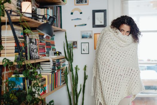 Woman Feeling Cold at Home with Shawl Wrapped Around her 