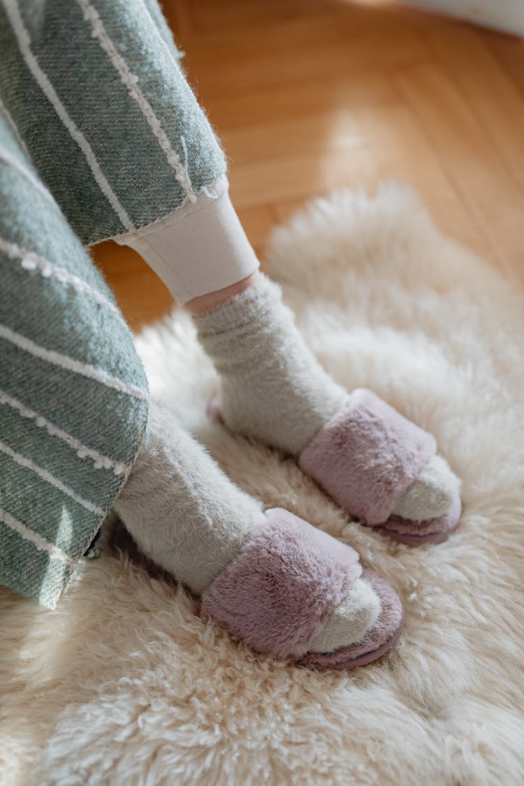 Close-up Of A Woman Wearing Fuzzy Socks And Cosy Slippers 