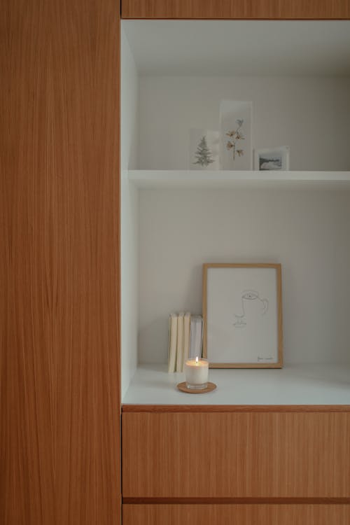 Lighted Candle on a Wooden Shelf