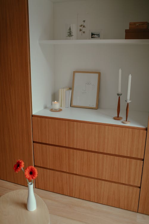 Red Flowers Beside a Wooden Cabinet