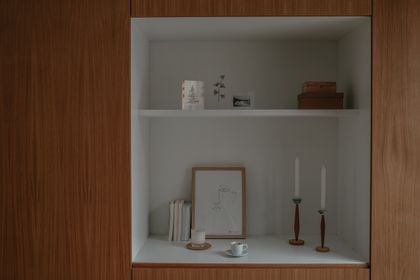 Brass taper candle holders on a shelf, photo by Cup of Couple on Pexels