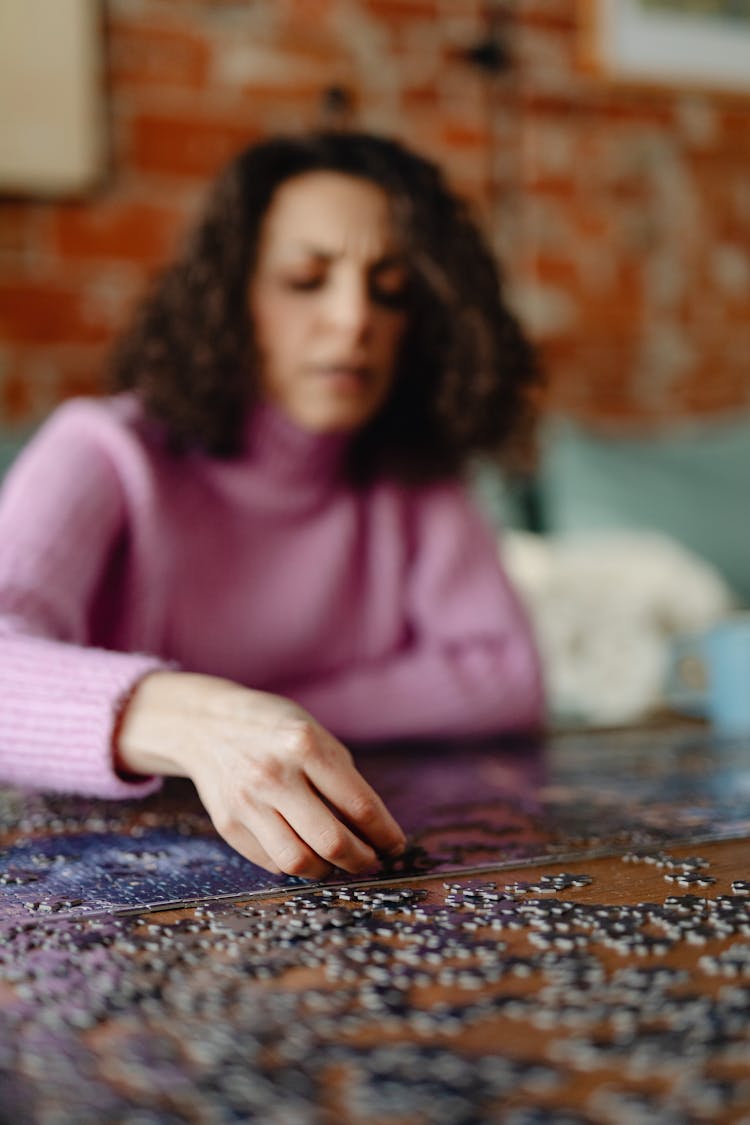 Blurred Portrait Of A Woman Solving Puzzles