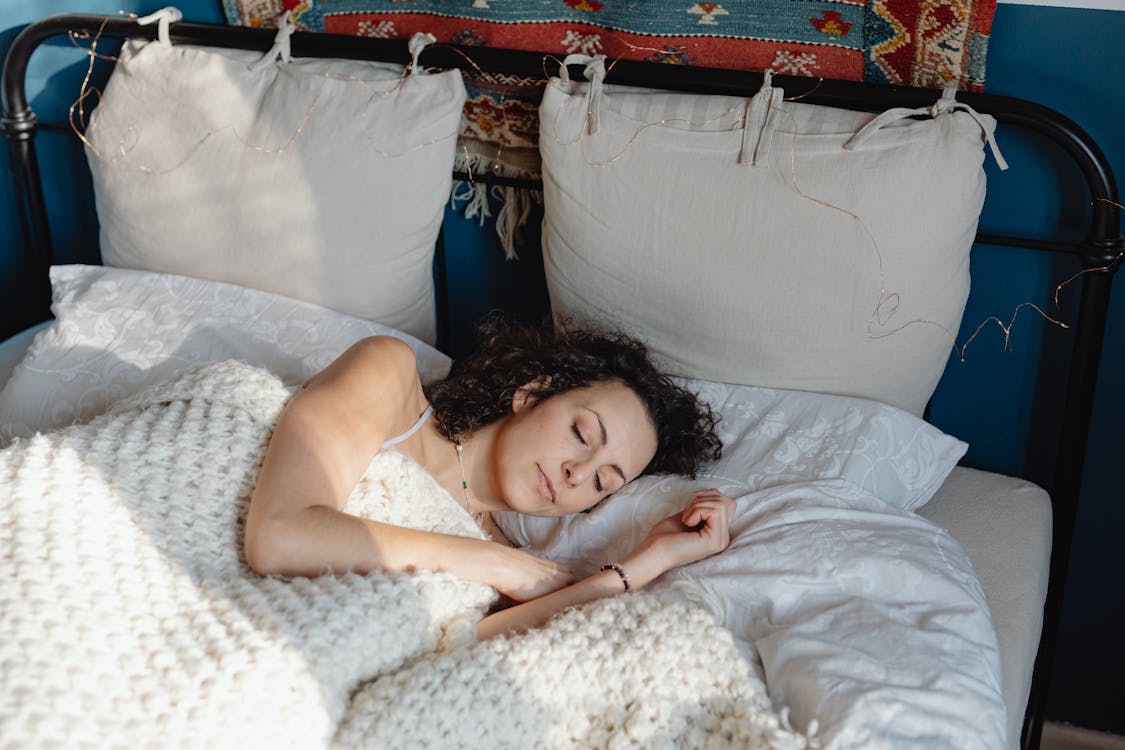 Free Young Woman Sleeping Under a Wool Blanket Stock Photo