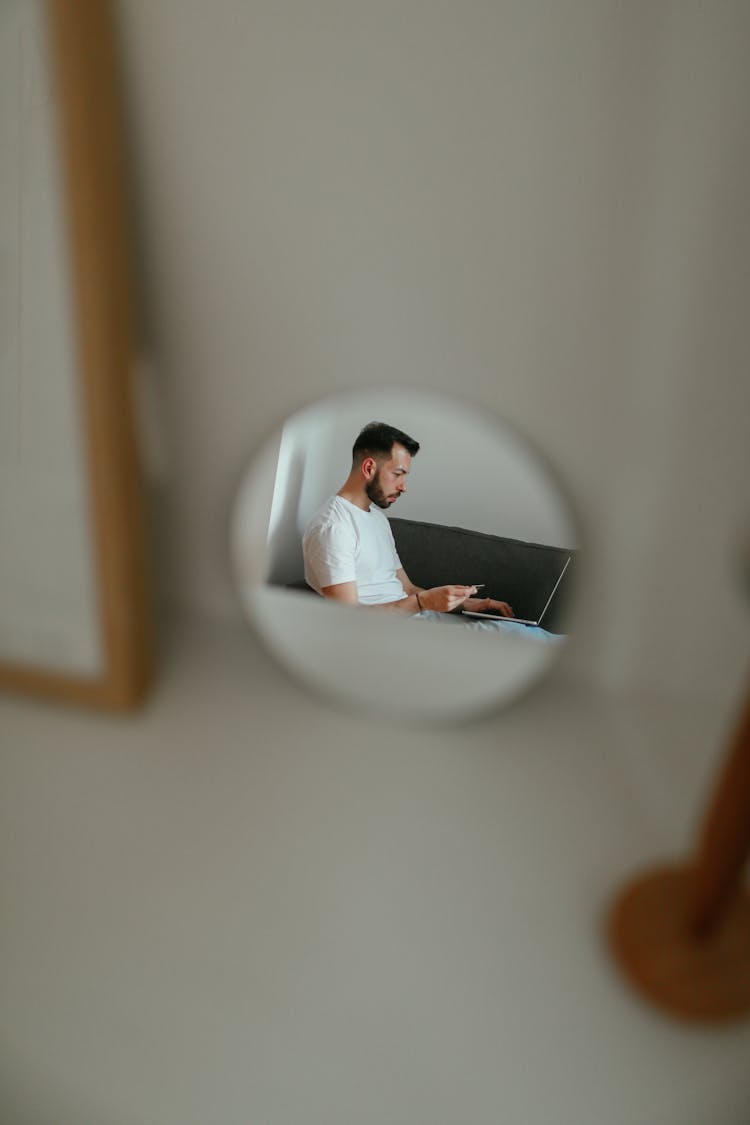 Reflection Of A Man Shopping Online Using Credit Card 