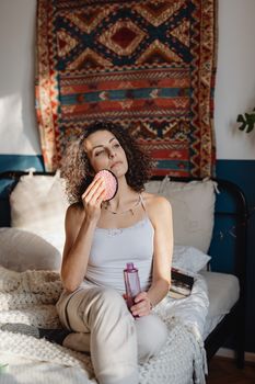 Woman in a cozy bedroom performs skincare routine, adding a relaxing touch to her day.