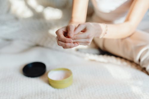 Close-up of a Woman Using a Cream on Her Hands 