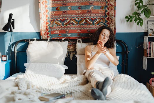 A woman lounges on her bed, surrounded by cozy decor and natural light.