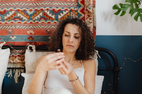 Portrait of a Woman Holding a Small Bottle of Cosmetic Oil and Rug in Background