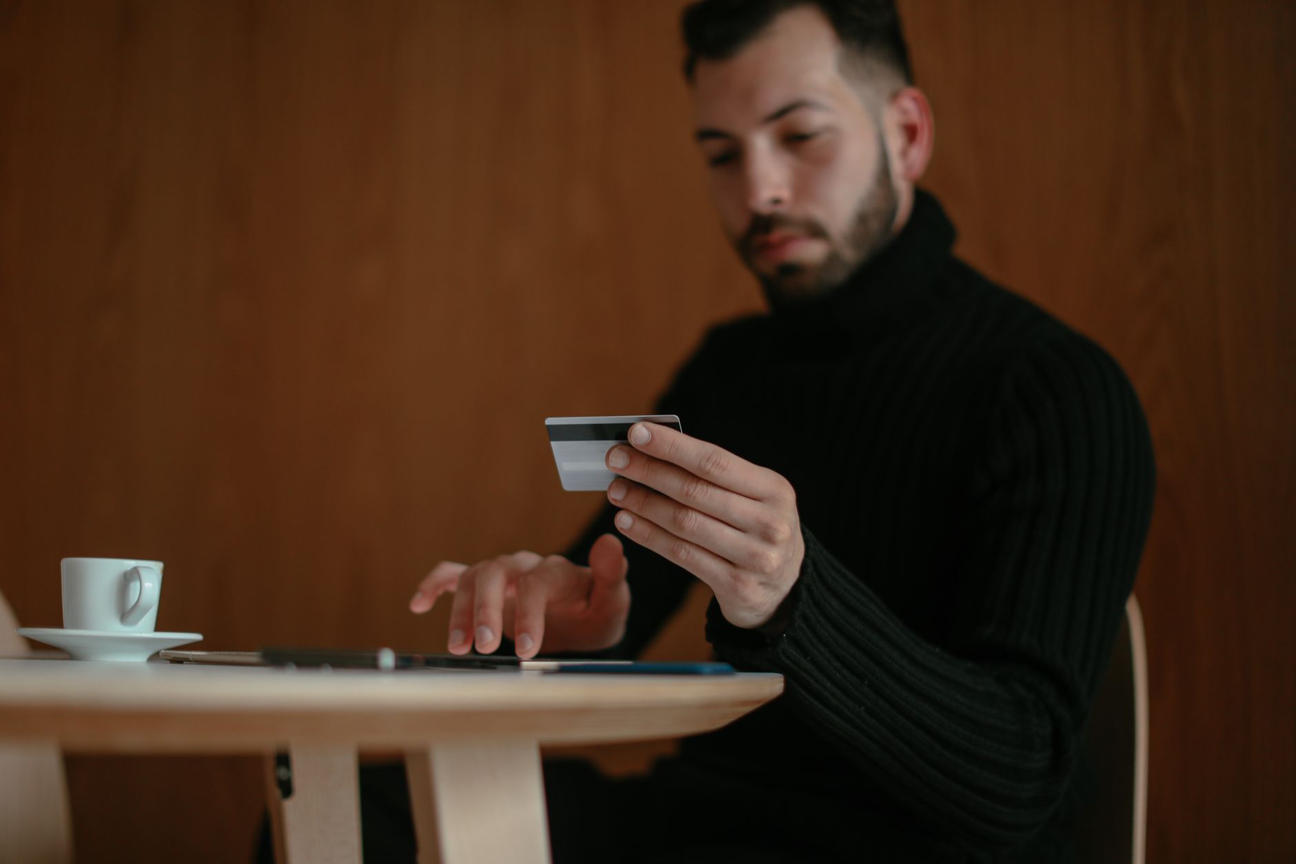 Focused man in café using tablet and credit card for online shopping. (Photo by Cup of Couple on Pexels)