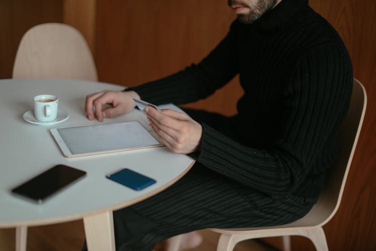 Man Shopping Online At Home Using His Tablet And Credit Card 