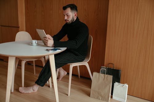 Man in Black Long Sleeve Shirt Using Digital Tablet