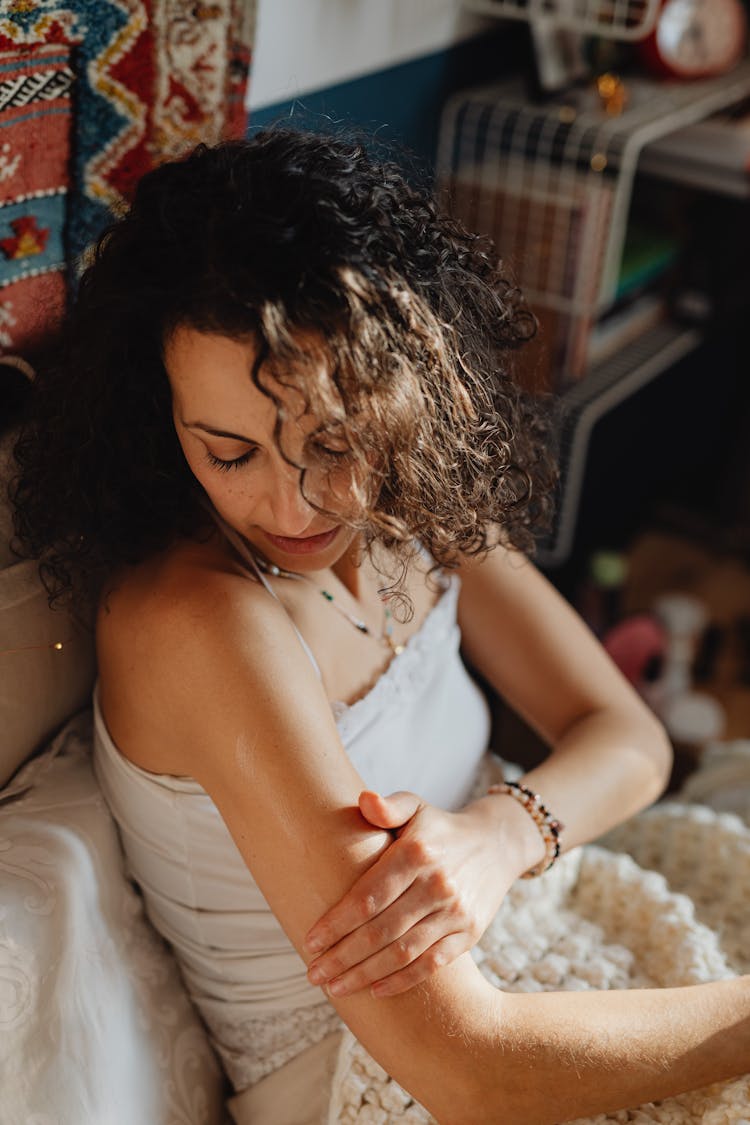 Woman With Curly Hair Touching Her Skin