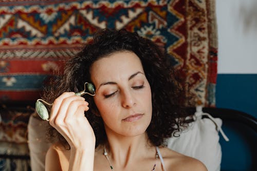 Woman Using a Face Roller for a Face Massage 