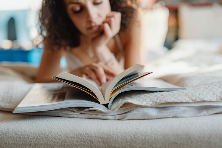 Woman Lying On Front Reading A Book