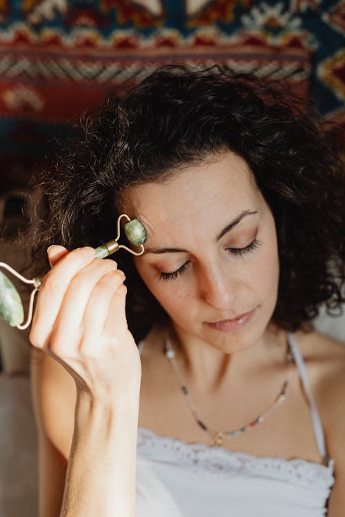 Free Woman Massaging Her Forehead With A Jade Roller Stock Photo